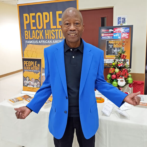 Kingsley H. Smith in front of People In Black History Book banner